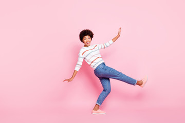 Fototapeta na wymiar Full body profile photo of pretty dark skin lady at dancing class learning new modern moves wear striped pullover and jeans isolated pastel pink color background