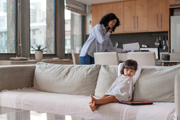Busy mother and entrepreneur working and looking after her daughter
