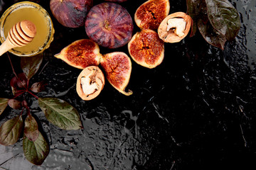 Autumn frame background. Autumn food still life with season fruits grape and figs, honey on a black table. Thanksgiving day.