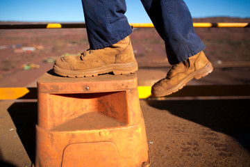 Miner worker wearing heavy duty steel cap boot using safety step white working at height to...