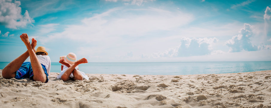 Father With Little Daughter Relax On Beach