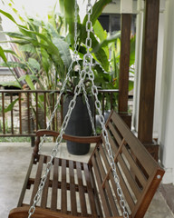 The detail of brown wood swing in the backyard.