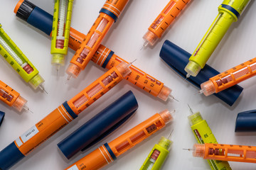 Stack of used insulin injectors or syringes of pen type - obrazy, fototapety, plakaty