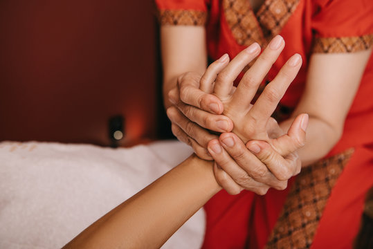cropped view of masseur doing hand massage to woman in spa salon