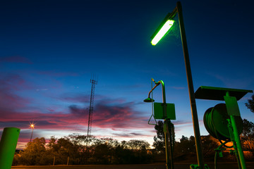 Green sign indicator emergency safety shower light station at Hope down 1 cape site with sunset at...