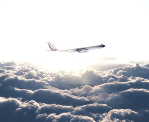 Naklejka na ściany i meble airplane flying over the white clouds