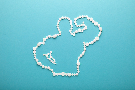 Silhouette of muscular bodybuilder made of pills of sport meal and supplements. Arginine alpha-ketoglutarate (AAKG) and Creatine capsules.