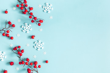 Christmas or winter composition. Snowflakes and red berries on blue background. Christmas, winter,...