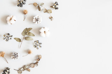Winter composition. Dried leaves, cotton flowers, berries, pine cones on gray background. Autumn, fall, winter concept. Flat lay, top view, copy space