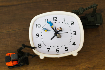 Miniature people : The team is working on an alarm clocks ,  working time concept