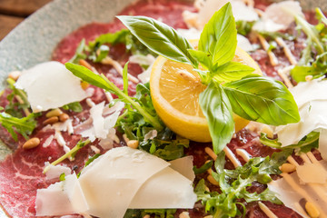 White dish with carpaccio of beef