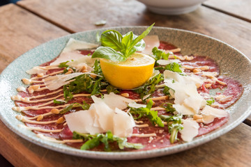 White dish with carpaccio of beef