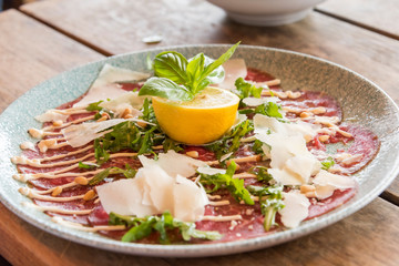 White dish with carpaccio of beef