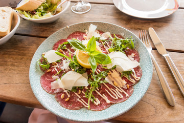 White dish with carpaccio of beef