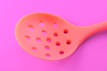 silicone kitchen skimmer on pink background closeup