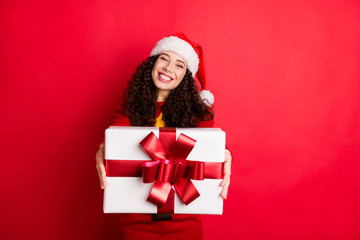 Portrait of her she nice attractive lovely charming cheerful cheery glad generous wavy-haired Santa girl giving bow ribbon box isolated on bright vivid shine vibrant red color background