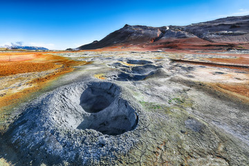 Boiling mudpots in the geothermal area Hverir and cracked ground around.
