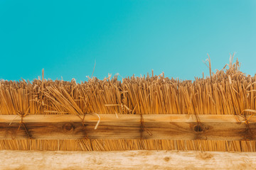 straw beach umbrella with blue sky