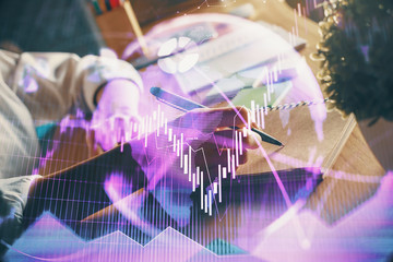 Naklejka premium Financial forex charts displayed on woman's hand taking notes background. Concept of research. Double exposure