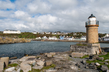 Fototapeta na wymiar Looking at view of Lighthouse and Harbour of Portpatrick in Dumfries and Galloway in Scotland. Sunny day in autumn in the south west of Scotland.
