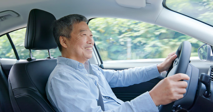 asian elderly man driving car