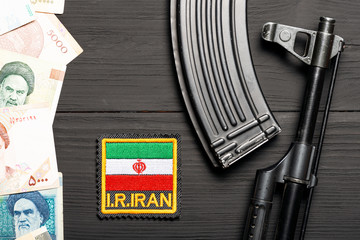 Obraz premium Soviet automaton AK 47 against the backdrop of Iranian money depicting Ruhollah Khomeini and Iranian flag