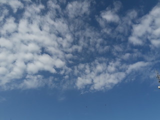 A beautiful horizontal shot of bright blue sky with puffy white clouds. 