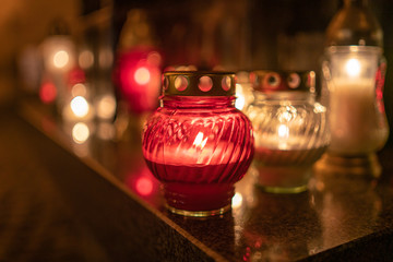 Jars with burning candles on stone surface at night