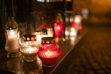 Jars with burning candles on stone surface at night