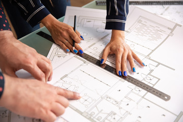Close up with the hands of two architects who check something in a house plan