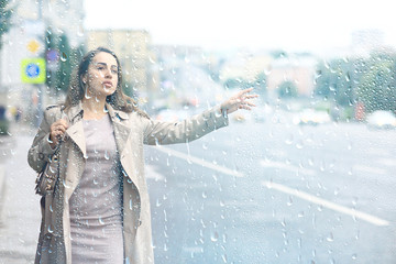 woman catches a car on the road, an adult young girl is waiting for a taxi, stops a passing vehicle, hitchhiking