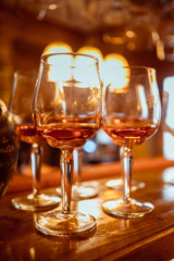 Cold and refreshing summer cocktail. Drinks and hospitality concept. Vertical image with selective focus. Glass of cocktail in the front, other bottles are behind in the background.