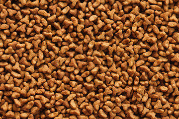 Dry pet food texture background. Medium size triangular pieces. Food pattern. Chewing treats for pets. Isolation on white. Your text space.