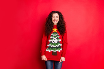 Portrait of funny funky cheerful positive girl get seasonal comfy sweater jumper with stylish trendy christmas tree decor for x-mas newyear gift isolated over red color background