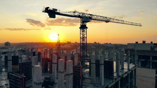 Urban construction site with cranes at sunset