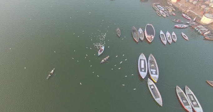 Aerial view above a flock of birds in a boat harbor in Varanasi, India. 