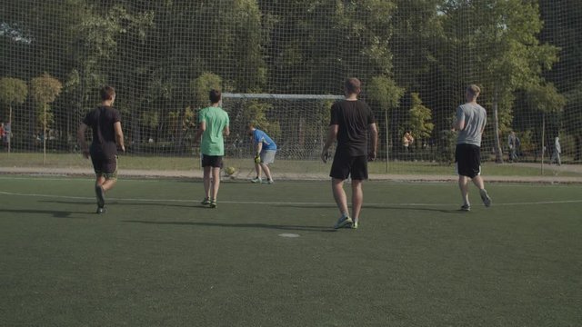 Frustrated football goalkeeper conceding a goal from penalty kick during soccer match, expressing despair and disappointment. Annoyed goalie taking the ball from net after successful penalty shot.