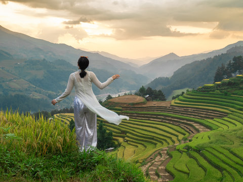 Woman in white Vietnamese national costume or Ao Dai at Mu Cang Chai rice terraces in Northern Vietnam.