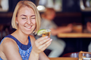 young woman in a restaurant drinks tequila