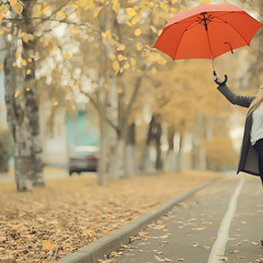 girl with a red umbrella, flying on an umbrella, jumping and having fun in a yellow autumn landscape