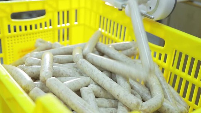 Production line of sausages closeup.Female Worker hands control the operation of the sausage production line. Meat processing plant for the production of sausages.