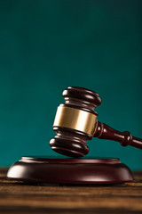 brown gavel with a brass band on wooden table.