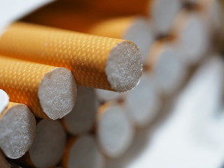 close up of the cigarette filters contained in an open packet, with a slightly drawn cigarette ready to be smoked
