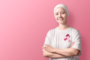 Asian woman in a white shirt with pink ribbon over pink background