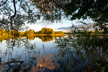 Sunset on the lake. Beautiful sunset nature. Evening landscape. Clouds over the lake.