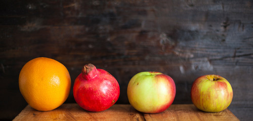 grapefruit apple and pomegranate on wooden table, isolated