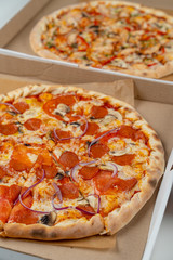Italian pepperoni pizza in the cardboard box close up