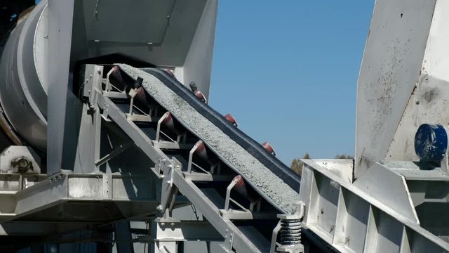 The conveyer belt transports gravel on asphalt plant. Manufacturing process