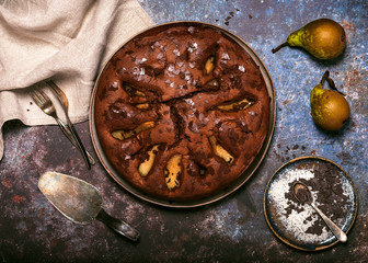 Top view of homemade delicious chocolate cake with pears in rustic style. Sweet food concept.