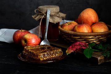 The jar with honey and apples in a wicker basket close-up